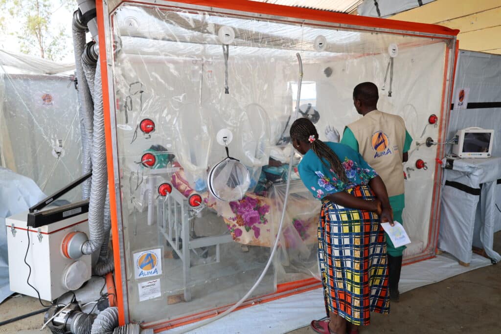 Le Dr Modeste et le Dr François en intervention médicale dans une unité CUBE biosécurisée d'ALIMA au CTE de Rwampara.