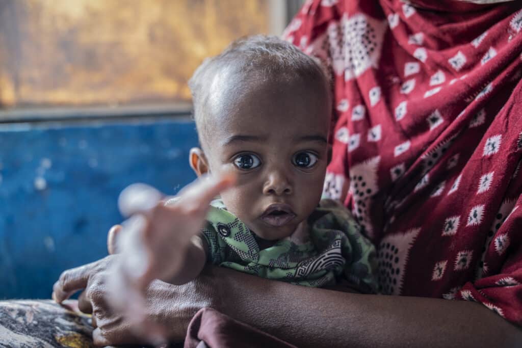 Young Khader regaining strength in his mother Sahra's arms after receiving malnutrition treatment supported by ALIMA at Hargelle hospital.