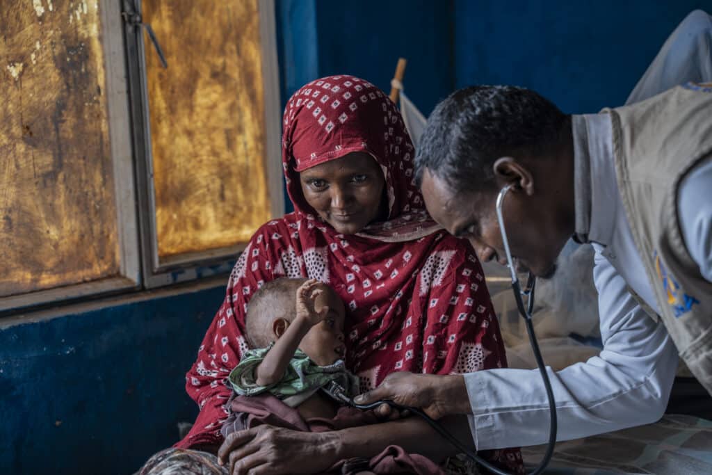 A health worker examines young Khader, held by his mother Sahra, at the ALIMA-supported Hargelle hospital in the Somali Region of Ethiopia.