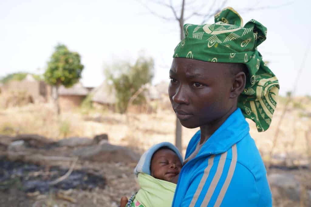 Portrait de Catherine, jeune mère de 19 ans, tenant sa fille Cécile à Mokolo dans la région de l’Extrême-Nord au Cameroun.